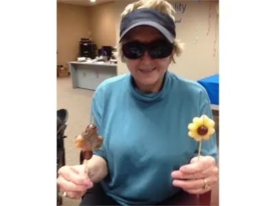 Lady holding fruit lollipops with chocolate dips